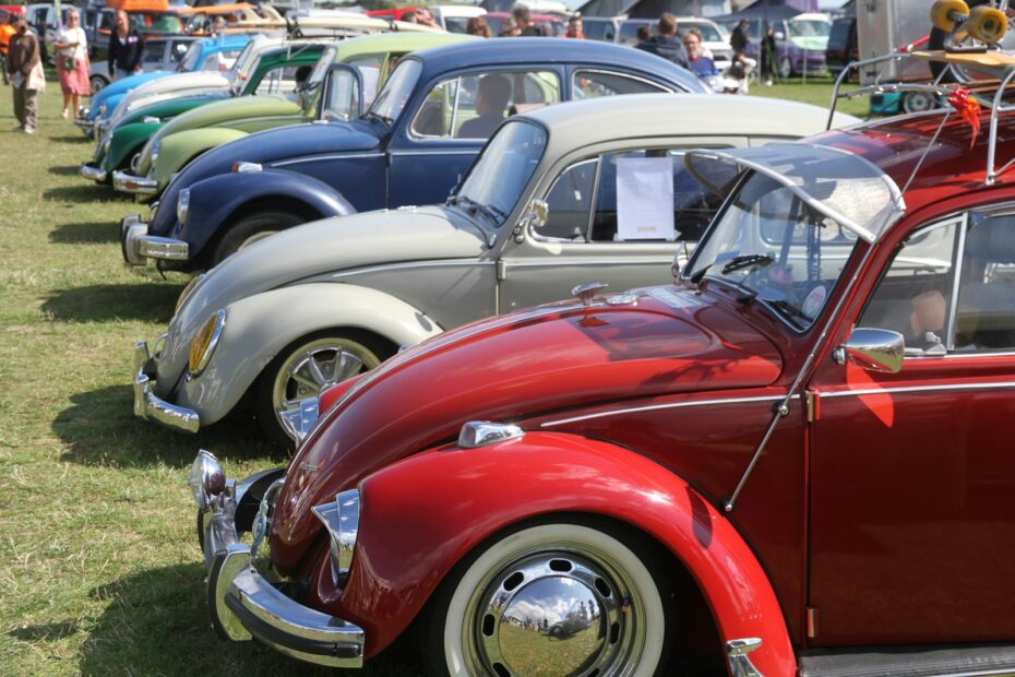 a row of cars parked next to each other on a field